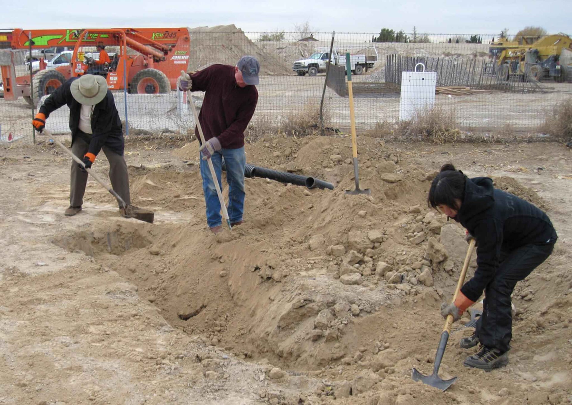 Blue-collar tradespeople standing together with their work tools